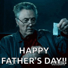 a man holding a piece of paper that says happy father 's day on it