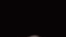 two men are fighting in a dark room .