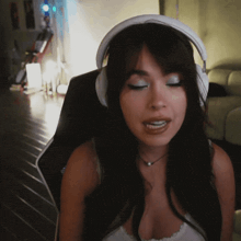 a woman wearing headphones is sitting in a gaming chair