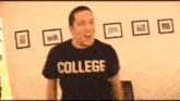 a man wearing a college t-shirt is standing in a living room .