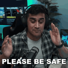 a man wearing headphones says " please be safe " in front of a microphone