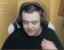 a man wearing headphones is sitting in front of a screen that says ' u ' on it