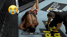 a man laying on the ground in a ufc ring