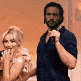 a man holding a microphone stands next to a woman who has the word me on her shoulder