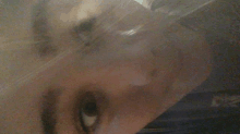 a close up of a person 's eye behind a clear plastic cover