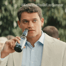 a man in a suit is drinking from a bottle with the hashtag #iknowwhatyou did last summer