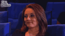 a woman is sitting in a movie theater with a sign that says yo me llamo behind her