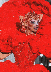 a woman in a red dress has a cat face painted on her face ..