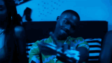 a man sitting on a couch with a green shirt that says champion on it