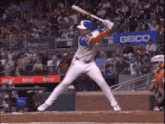 a baseball player getting ready to swing at a ball with a geico sign in the background