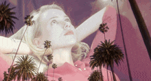 a woman in a pink dress with palm trees behind her