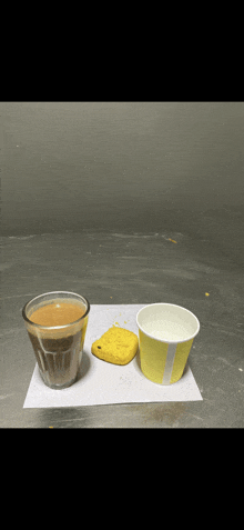 a cup of tea sits next to a yellow cup of milk