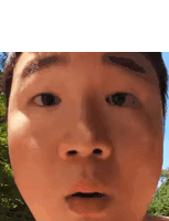 a close up of a man 's face with a surprised expression