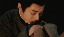 a close up of a man 's face with his eyes closed and his hand on his face .