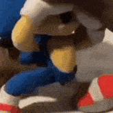 a close up of a stuffed sonic the hedgehog toy sitting on a table .