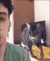 a man is taking a selfie with a cat in front of his face .