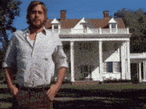 a man stands in front of a large white house with the word may on the bottom