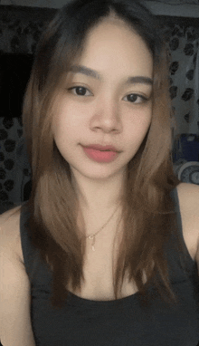 a woman in a black tank top is looking at the camera