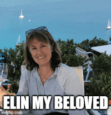 a woman sitting at a table with the words elin my beloved written below her