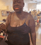 a woman wearing a black tank top is standing in a store