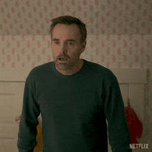 a man standing in front of a wall with netflix written on the bottom