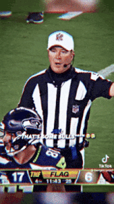 a referee is talking to a football player on a television screen