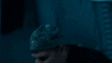a man in a black jacket is holding a flashlight in his hand in a dark room .