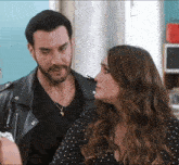a man and a woman are looking at each other and the woman is wearing a polka dot dress