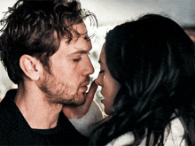 a man and a woman are kissing and the man is touching the woman 's face