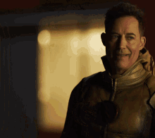 a man in a leather jacket with a flash logo on his chest