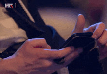 a close up of a person using a cell phone with hrt 1 written on the bottom