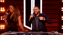 a man and a woman are sitting at a table with microphones and the words titangames on the bottom