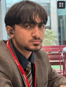 a man in a suit and tie with a lanyard around his neck that says ' microsoft ' on it .