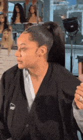 a woman is getting her hair done in a salon wearing a jacket that says aveda