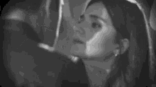 a man and a woman kissing in a black and white photo .