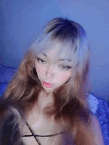 a girl with long hair is taking a selfie with a blue light behind her