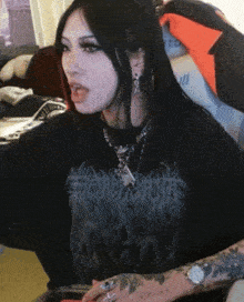 a woman wearing a black t-shirt with a skull on it is sitting in a chair