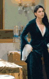 a woman in a green dress is standing in a room