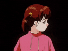 a girl with pigtails is smiling and wearing a pink hoodie