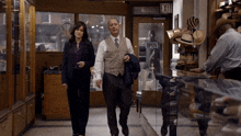 a man and a woman are walking in a store with an exit sign above them