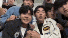 a group of young men are standing next to each other and smiling for the camera .
