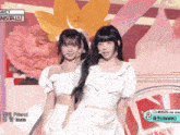 two girls on a stage with a sign that says # 0505