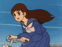 a girl in a school uniform is riding a bike .