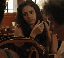 a woman sitting at a table with a louis vuitton purse on her lap