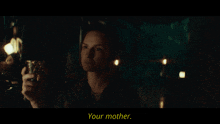a woman in a dark room is holding a cup and says your mother