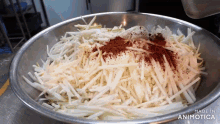 a metal bowl filled with shredded vegetables and spices with the words made in animotica below it