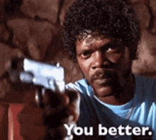 a man is pointing a gun at the camera with the words you better written below him .