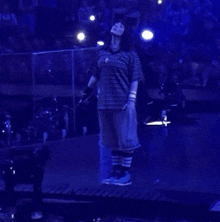 a person wearing blue shorts and striped socks is walking in the dark