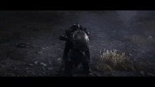 a person in a helmet is standing in the dark in a field .