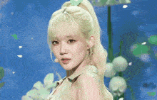 a woman with blonde hair is wearing a green shirt and a green bow in her hair